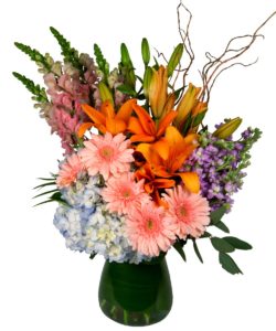 vibrant orage lilies with peach daisies and greenery in vase