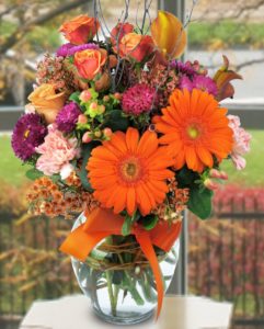 large orange daisies and pink and purple flowers in vase
